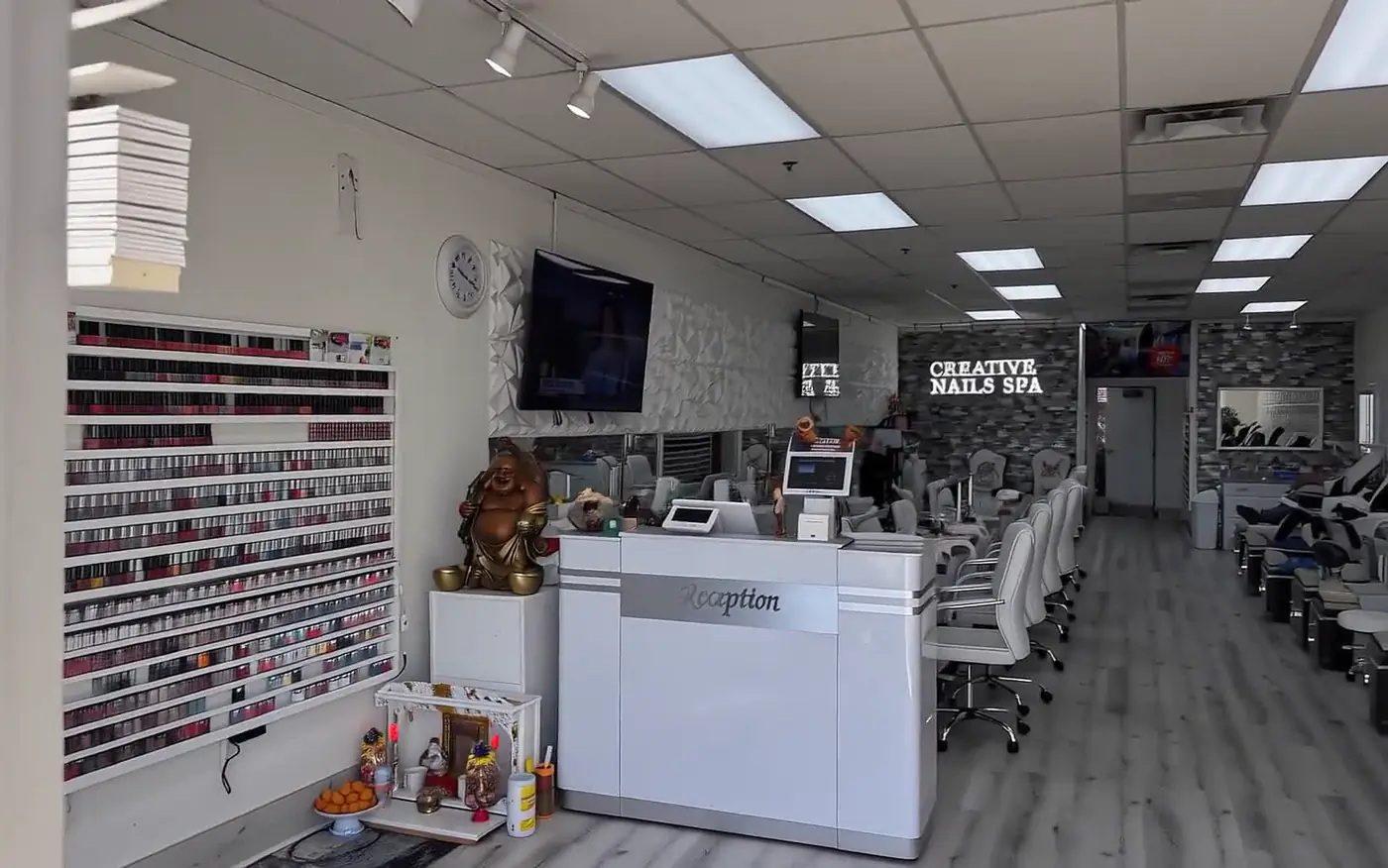 The inside of Creative Nails, with its wall of polish colours, reception desk and manicure stations